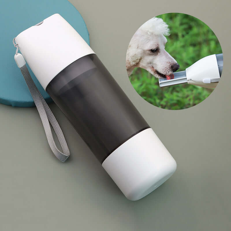 PELOSETTINSHOP Portable Dog Water Bottle 350ml with dispenser and dog drinking water outdoors.